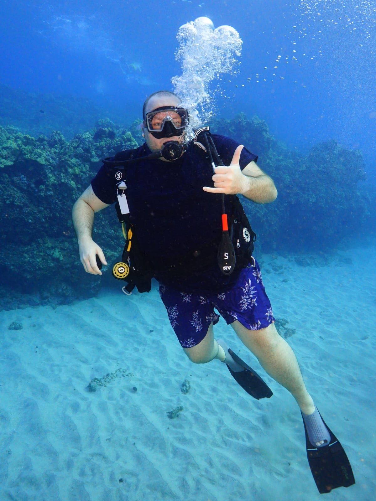 Maximilian Fischer beim Tauchen vor Hawaii, mit Shaka-Gruß in die Kamera
